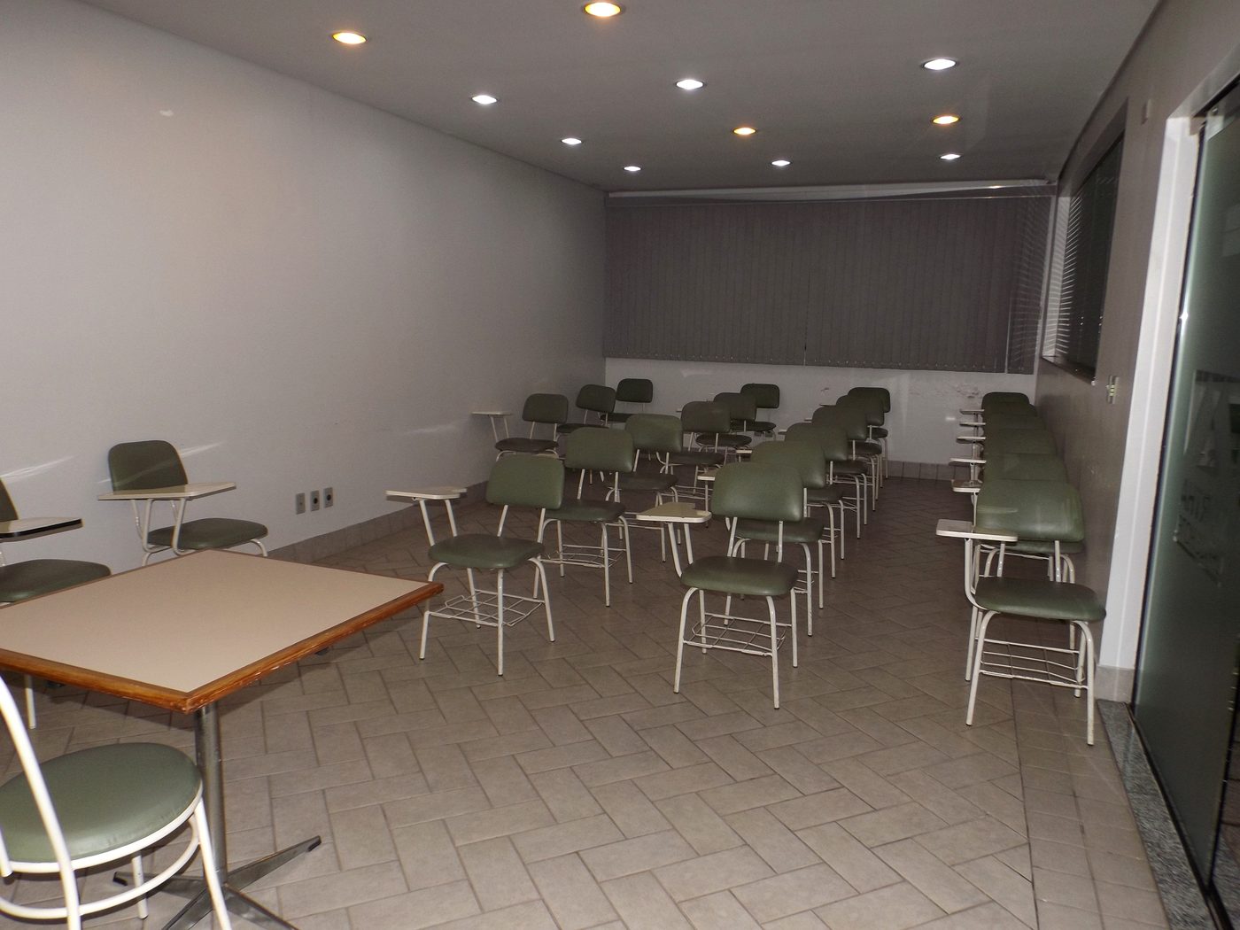 Salão de eventos do Martha Office Hotel montado em formato de auditório, com cadeiras e mesas de apoio